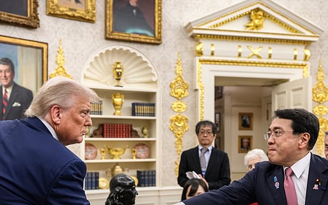President Donald J. Trump and Japanese trade negotiator Ryosei Akazawa, with other officials present in the background, July 23, 2025.