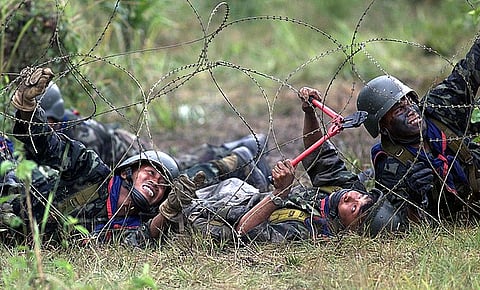 Royal Thai Army Infantry Soldiers practice breaching concertina wire during a combat tactics exercise.
