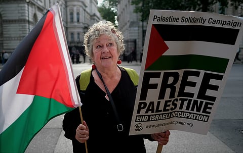 Palestine solidarity protester with Palestinian flag and "Free Palestine" placard opposite Downing Street, London on 5 June 2018. 