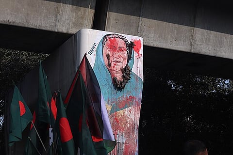 A protest scene where Sheikh Hasina's portrait becomes a focal point of public dissent, with individuals throwing shoes as a symbolic act of hatred and resistance against her regime.
