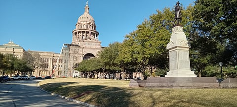 Texas State Capitol and trees on the grounds, along with the Volunteer Firemen Monument in Austin, Texas, United States during renovation of the front of the building