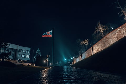 Slovakian Flag in between some buildings at night