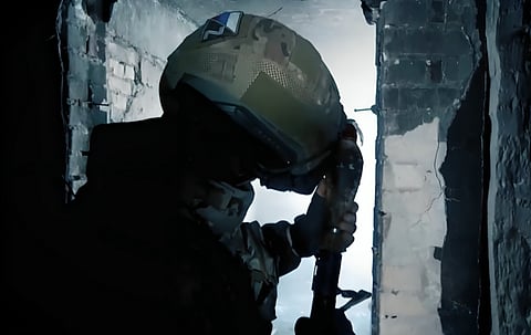 Picture of a russian soldier hiding inside a damaged building and reloading his manual rocket propelled mortar to shell Ukrainian positions