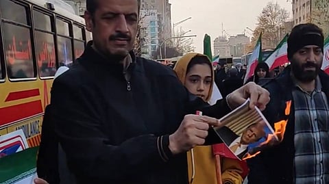 An Iranian protester set fire to an image of U.S. President Donald Trump during protests held on 14, January 2026.