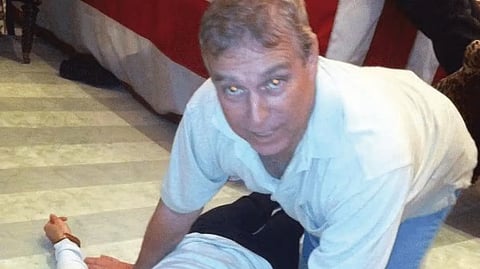 Images from the US DOJ show Andrew Mountbatten-Windsor on the floor with an unidentified person.