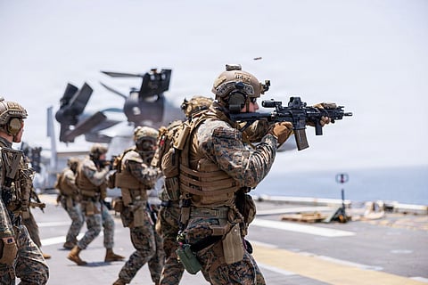 U.S. Marines fire weapons during a deck shoot aboard America-class amphibious assault ship USS Tripoli (LHA 7) in the Arabian Sea, April 2.