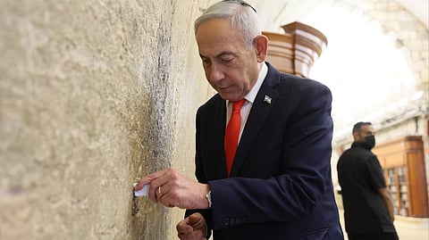 Netanyahu shared a photo of himself placing a handwritten note at the Western Wall, captioning it as his evening prayers there for the "victory of the people of Israel."