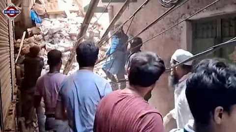 Rescue personnel and locals stand near debris amid rescue operation after a four-storey building collapsed at Welcome area, in New Delhi, Saturday, July 12, 2025.