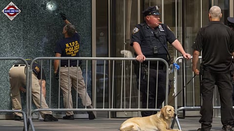 Members of the NYPD Crime Unit examine a door with bullet holes at the scene.