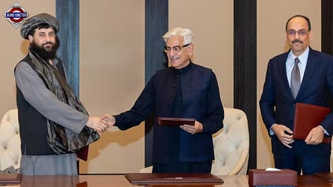 Afghanistan’s Defence Minister Mullah Muhammad Yaqoob shakes hands with Pakistani counterpart Khawaja Muhammad Asif during peace talks in Doha.