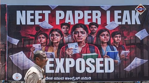 A police official passes by a poster during a protest staged by Youth Congress members over the alleged irregularities in the NEET-UG medical entrance exam