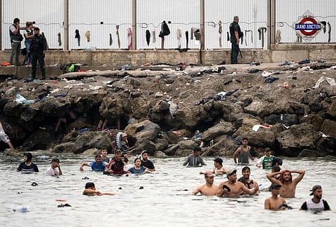Migrants gather near the Spain–Morocco border in Ceuta as thousands returned after citing hunger, lack of shelter and harsh conditions following the mass crossing.