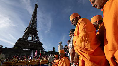 Bochasanwasi Akshar Purushottam Swaminarayan Sanstha (BAPS) Hindu monks take part in a religious ceremony in front of the Eiffel Tower.