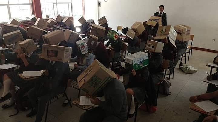 தலையில் அட்டை பெட்டியுடன் தேர்வு எழுதிய மாணவர்கள் : ஆசிரியரின் நடவடிக்கைக்கு பெற்றோர் எதிர்ப்பு!