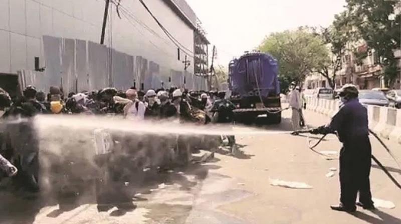 கொரோனா பரிசோதனைக்காக காத்திருந்த தொழிலாளர்கள் மீது கிருமிநாசினி தெளிப்பு - டெல்லியில் அதிர்ச்சி சம்பவம்!