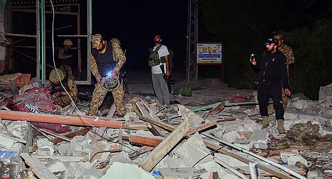 Army soldiers examine a building damaged by a suspected Indian missile attack near Muzaffarabad, the capital of Pakistan controlled Kashmir, Wednesday, May 7, 2025.