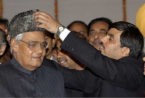 BJP’s Shah Nawaz Hussain adjusting Atal Behari Vajpayee’s Karakuli cap at an Iftar Party.