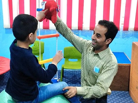 A therapy session being conducted with a child by rehabilitation therapist in Kashmir.