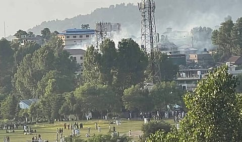 Smoke rises as people gather in Rawalakot, Pakistan administered Jammu and Kashmir, on June 7, 2026.