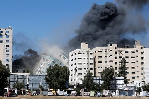 The al-Jalaa tower housing Al Jazeera and The Associated Press offices collapses after being hit by an Israeli missile in Gaza City in May 2021. [Al Jazeera via Mohammed Salem/Reuters]
