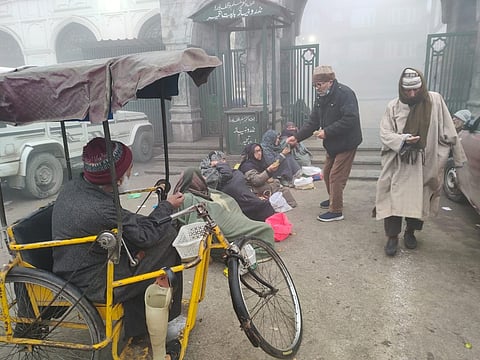 Some beggers seeking alms from passers-bye outside Jama Masjid in Srinagar on a foggy Friday, December 29, 2023. KT Photo/Qazi Irshad 
