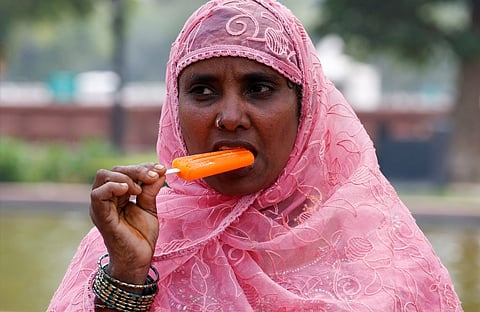 A woman eats an ice cream on a hot summer day in New Delhi, India, April 23, 2024. REUTERS/Priyanshu Singh
