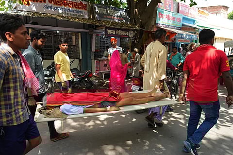 An elderly person suffering from heat related ailment is carried on a stretcher to a government hospital in Ballia, Uttar Pradesh state [Rajesh Kumar Singh/AP]
