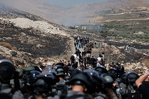 يتصاعد الدخان بينما يقف أفراد من شرطة الحدود الإسرائيلية على خط وقف إطلاق النار بين مرتفعات الجولان المحتلة وسوريا، 16 يوليو/تموز 2025. الصورة: أرشيف رويترز