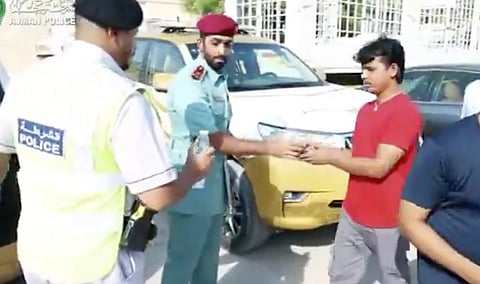 شرطة عجمان توزع المثلجات والمرطبات على العمال