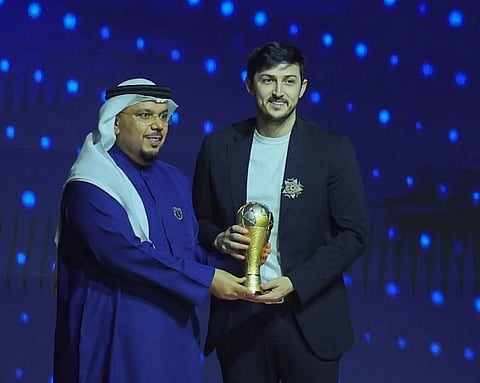 سردار أزمون لاعب شباب الأهلي يتسلم الجائزة.