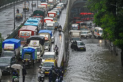 تشق المركبات طريقها عبر طريق غمرته المياه أثناء هطول أمطار غزيرة في مومباي في 19 أغسطس. الصورة: وكالة فرانس برس