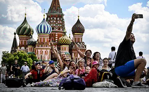 يلتقط السياح صورة شخصية في الساحة الحمراء أمام كاتدرائية القديس باسيل في وسط مدينة موسكو.