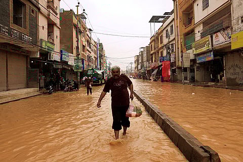 يحمل أحد السكان كيسًا من البقالة أثناء سيره في شارع غمرته المياه بعد هطول الأمطار، في أعقاب موسم الرياح الموسمية الأخير، في كراتشي، باكستان، 10 سبتمبر/أيلول 2025. الصورة: رويترز