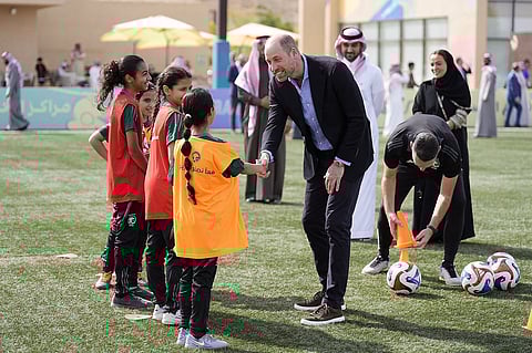 الأمير ويليام، أمير ويلز البريطاني، يتحدث مع مجموعة من لاعبات كرة القدم الشابات خلال زيارة لمدينة مسك الرياضية في الرياض، المملكة العربية السعودية.