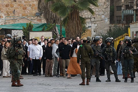 جنود إسرائيليون يقفون للحراسة خلال جولة أسبوعية للمستوطنين في الخليل، بالضفة الغربية المحتلة، 14 فبراير 2026