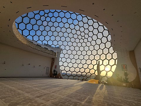 منظر داخلي للقبة الزجاجية العملاقة لمسجد النصر. تعكس الألواح السداسية ضوء غروب الشمس الذهبي عبر مساحة الصلاة. الصور: SM Ayaz Zakir