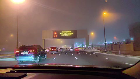 لوحات إلكترونية تعرض تنبيهات السلامة مع غطاء ضباب كثيف يلف أجزاء من الإمارات.