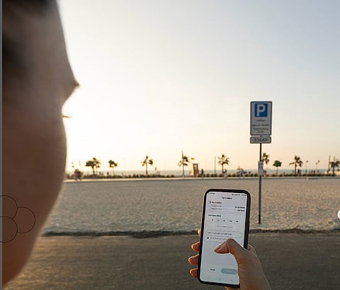 سائق يحاول دفع رسوم مواقف السيارات عبر تطبيق باركين. الصورة تستخدم لأغراض توضيحية.