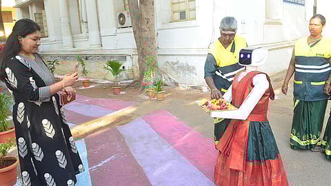 வாக்குச்சாவடியில் வாக்காளர்களை சாக்லெட் கொடுத்து வரவேற்ற ரோபோ