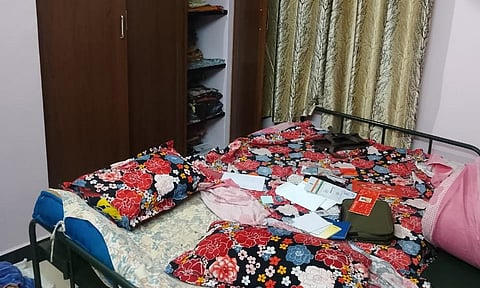 முகமூடி ெகாள்ளை நடந்த வீட்டில் பீரோவில் இருந்த துணிகள் சிதறி கிடந்த காட்சி.