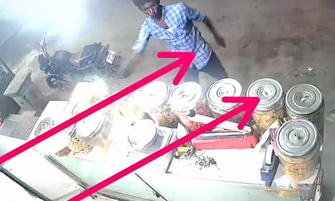 பேக்கரியில் வைத்திருந்த பாட்டில்களை வாலிபர் வாளால் வெட்டும் காட்சி.