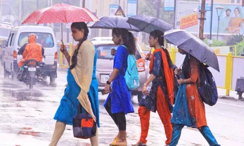 வண்ணார்பேட்டையில் இன்று காலை பெய்த மழையால் குடை பிடித்து சென்ற மாணவிகள்.