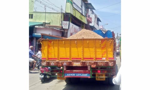 தார்பாய் கொண்டு மூடாமல் மணல் ஏற்றி செல்லும் லாரி.