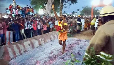 கைக்குழந்தையுடன் பூக்குழி இறங்கிய பக்தர்.