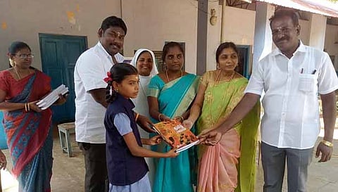 மாணவி ஒருவருக்கு நோட்டு, புத்தகங்கள் வழங்கப்பட்ட காட்சி.