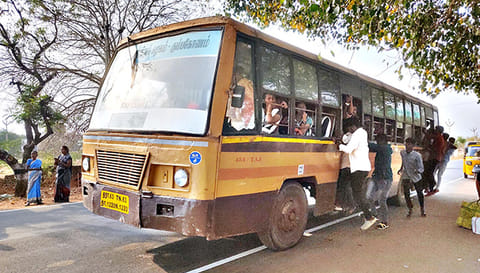 பஸ்சில் தொங்கி செல்லும் பயணிகள்.
