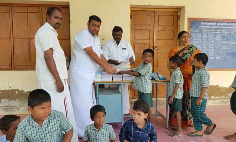 பள்ளி மாணவர்களுக்கு நோட்டு புத்தகம் வழங்கிய காட்சி