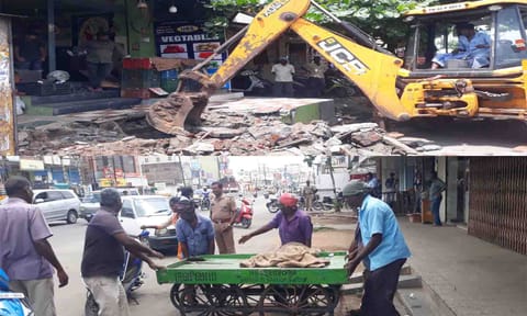 கடைகள் முன்பிருந்த ஆக்கிரமிப்புகள் பொக்லைன் எந்திரம் மூலம் அகற்றப்பட்ட காட்சி. தள்ளுவண்டியை அப்புறப்படுத்திய பணியாளர்கள்.