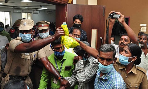 வேலூர் கலெக்டர் அலுவலகத்தில் தீக்குளிக்க முயன்றவர்களை போலீசார் தடுத்து நிறுத்திய காட்சி.