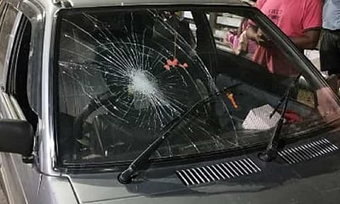 சேதம் அடைந்துள்ள கார் கண்ணாடியை படத்தில் காணலாம்.